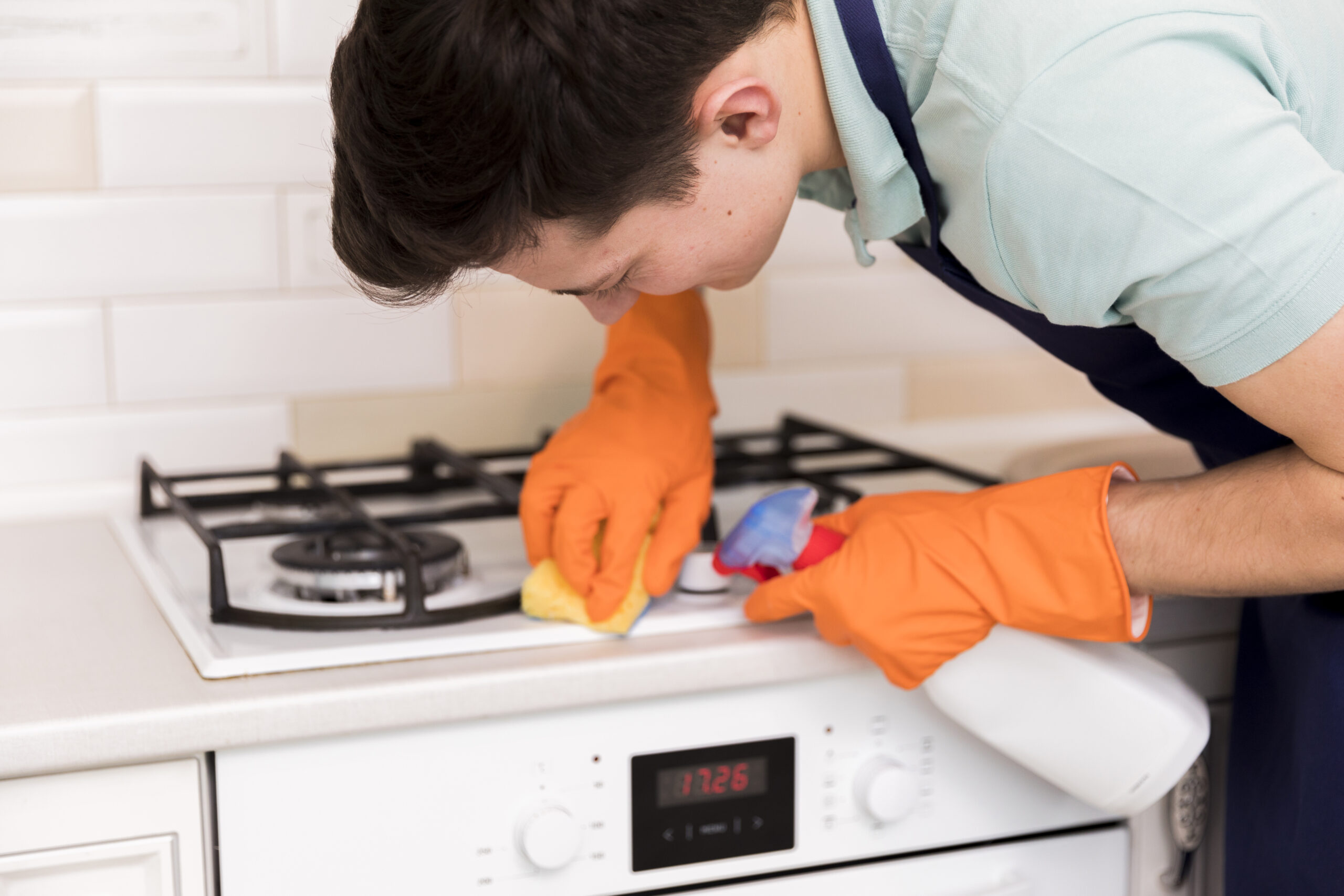 man cleaning his gas stove stop